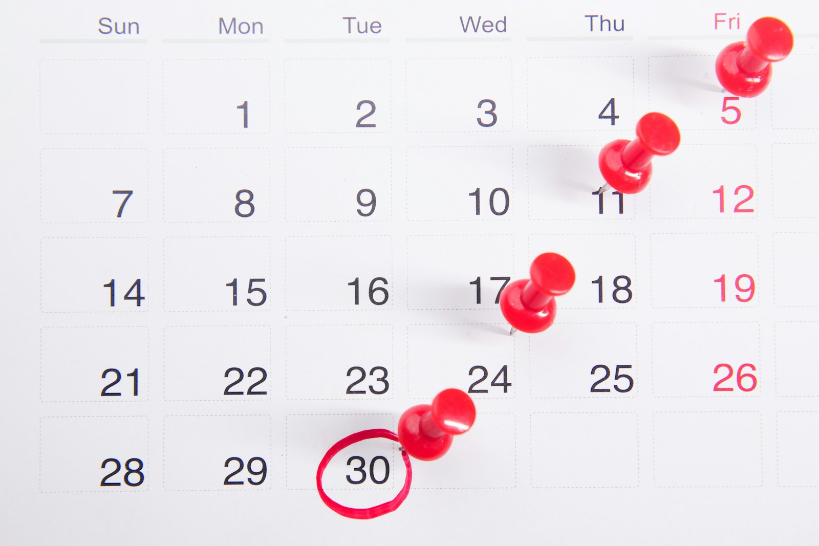Photo by Towfiqu barbhuiya a calendar with red push buttons pinned to it